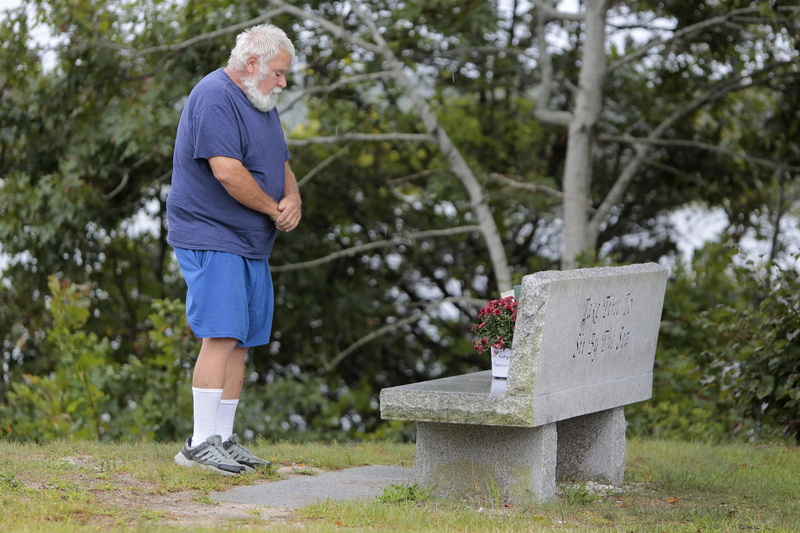 Steve Roberts prays after placing some flowers atop the stone bench in Wareham, which is dedicated in memory of Peter A. Gay, who was aboard one of the two planes which crashed into the World Trade Center on September 11, 2001.  Mr. Roberts and his wife were driving up from Florida, when they saw one of the two towers falling, as they were driving past New York on that fateful day.  PHOTO PETER PEREIRA