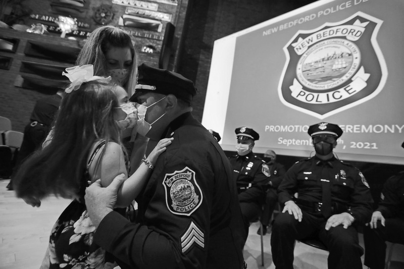 New Bedford Police officer Kevin Lawless, gives his daughter Morgan Lawless, 4, a kiss after she and her mother, Kara Lawless pinned the sergeant badge on his uniform during a promotion ceremony held in the Whaling Museum auditorium.