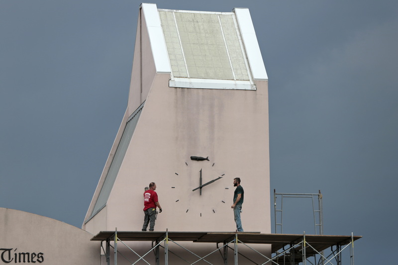 Workmen evaluate the clock tower of the Bay Coast Bank in downtown New Bedford, before making repairs to the stucco.  PHOTO PETER PEREIRA