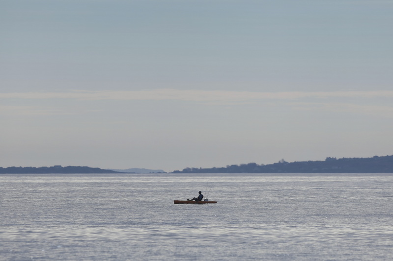 A man makes his way across open water off of East Beach in Westport, MA.  PHOTO PETER PEREIRA