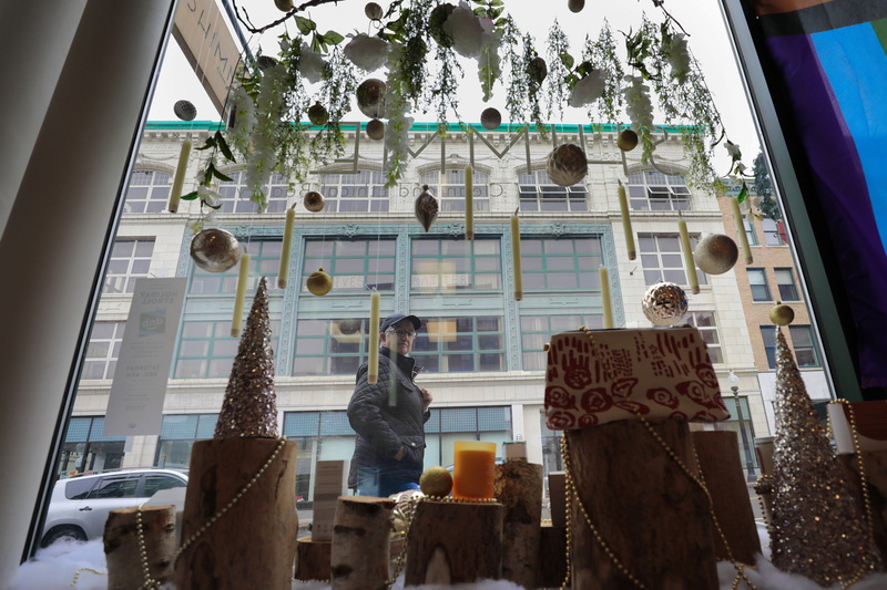 A pedestrian walks up Union Street in downtown New Bedford past the storefront window of Shimmer which has been decorated in preparation for Small Business Saturday which happens every year the Saturday after Thanksgiving. PHOTO PETER PEREIRA