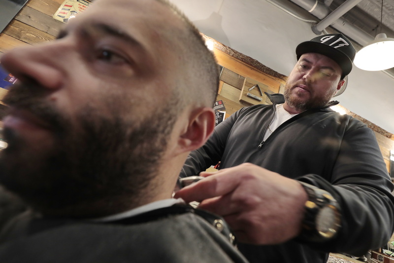 Jeff Saint gives Ryan Arruda a haircut at New Bedford Barber Co. on William Street in New Bedford, MA. PHOTO PETER PEREIRA