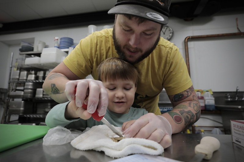 Joshua Lemaire teaches his son Sam Lemaire, 4, how to shuck an oyster in his newly opened Union Flats restaurant at 37 Union Street in downtown New Bedford, MA. PHOTO PETER PEREIRA