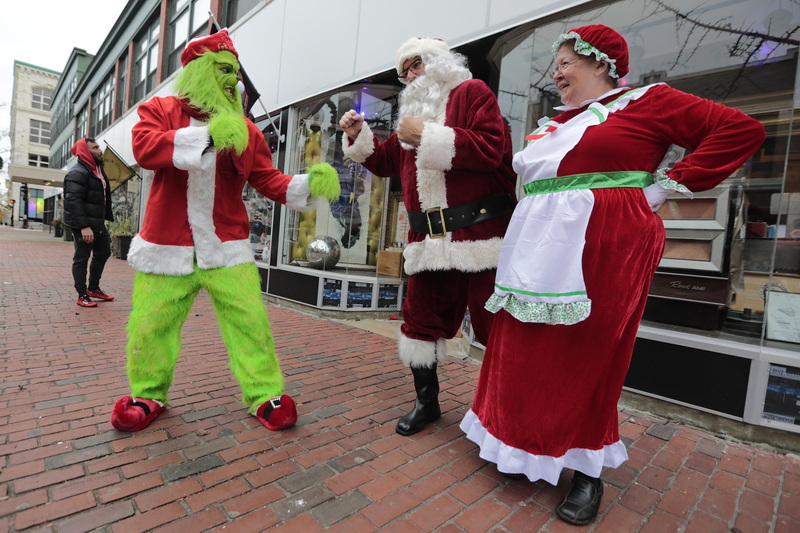 The Grinch (Brandon Webb) and Santa Clause and Mrs. Clause (who happen to be driving by and spotted their foe) put up their dukes in front of Cojo's Toy World on Purchase Street in New Bedford, MA. PHOTO PETER PEREIRA