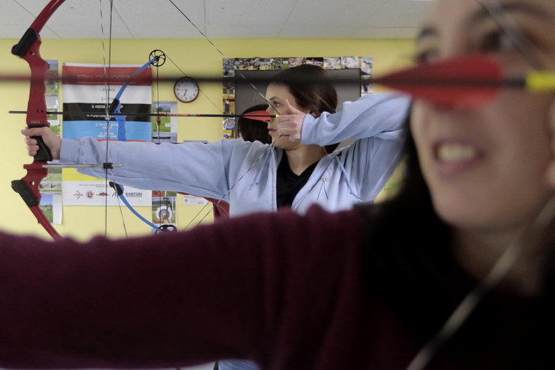 Hannah Rounseville and Tiffany Marchisin work on their marksmanship during adult class at Dee's Archery on Bedford Street in Lakeville, MA.