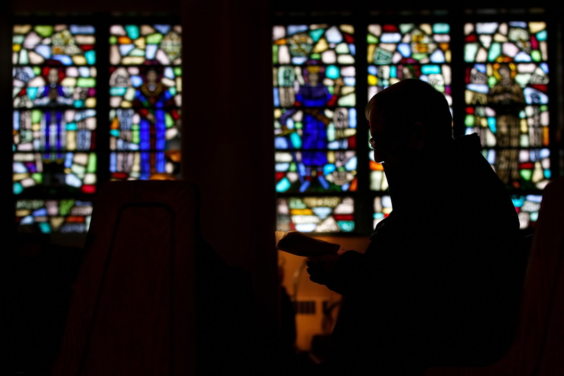 A man reads from a small prayer book inside of Our Lady's Chapel on Pleasant Street in New Bedford, MA. PHOTO PETER PEREIRA