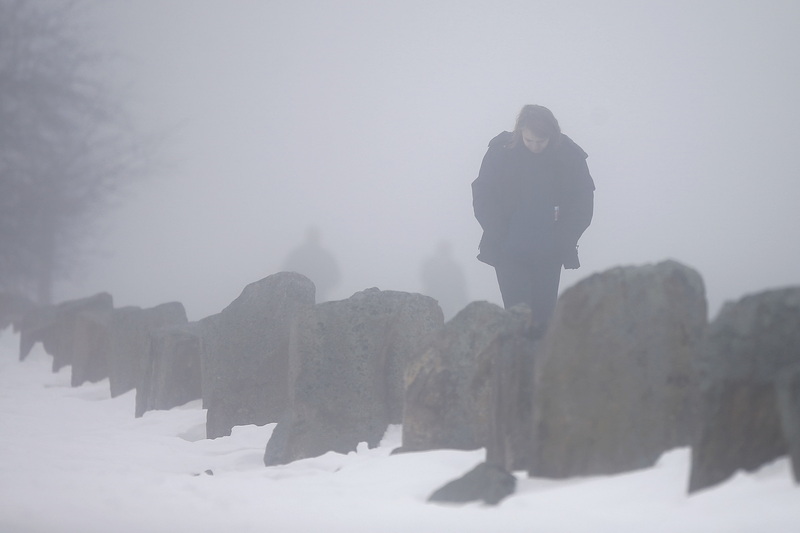 A woman goes for a walk on top of the hurricane barrier at Fort Phoenix in Fairhaven, MA on a foggy morning.