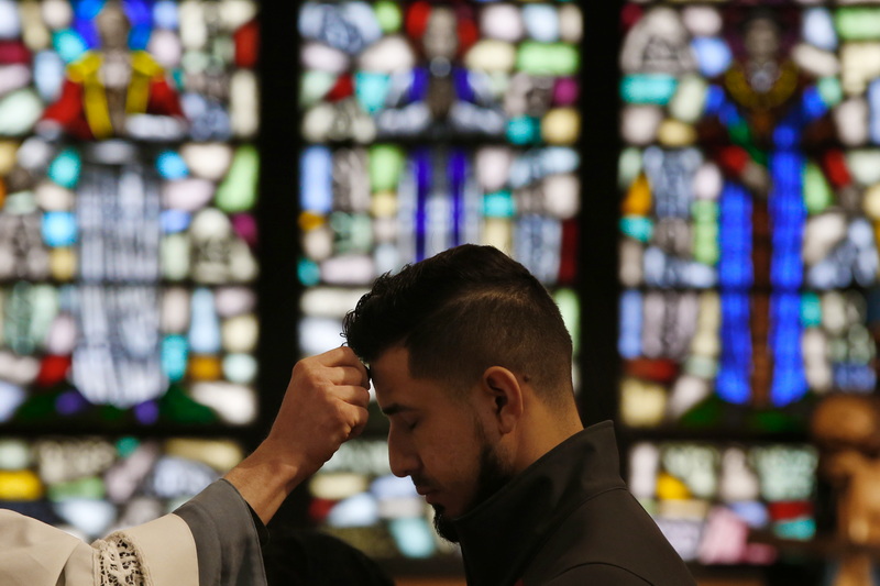 Father Matthias places ashes on the forehead of a parishioner at Our Lady's Chapel in downtown New Bedford, MA on ash Wednesday. PHOTO PETER PEREIRA