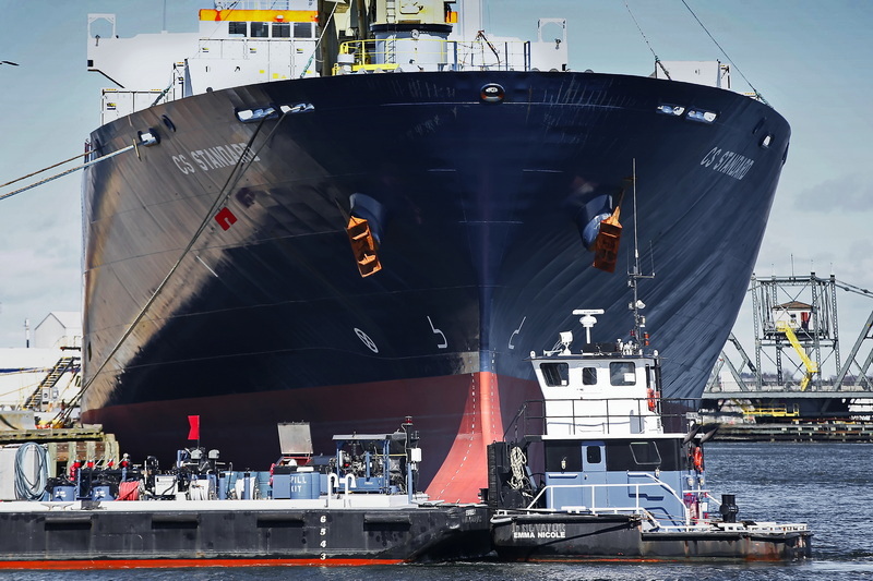 The cargo ship CS Standard, docked at State Pier in New Bedford, dwarfs the refueling barge making its way across its bow. PHOTO PETER PEREIRA