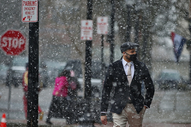 A dapper dressed man makes his way down Purchase Street in downtown New Bedford, MA as snow starts fralling across the region.  PHOTO PETER PEREIRA