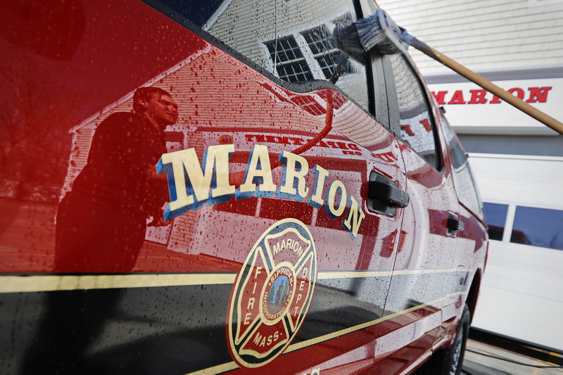 Marion EMT, Jake Tura is reflected on the door as he washes the Squad 1 car in front of the fire station on Spring Street in Marion, MA.  PHOTO PETER PEREIRA