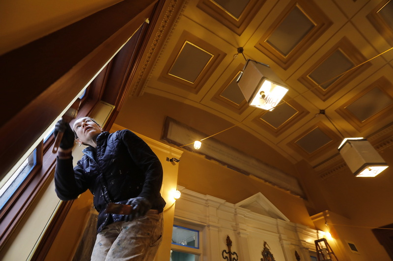 Jennifer Rydwansky of Village Green Restoration paints the wood grain glazing of the window casings, after having completed the elaborate vaulted ceiling of the New Bedford Whaling National Historic Park Visitor Center, which is due to re-open after major renovations next month. PHOTO PETER PEREIRA