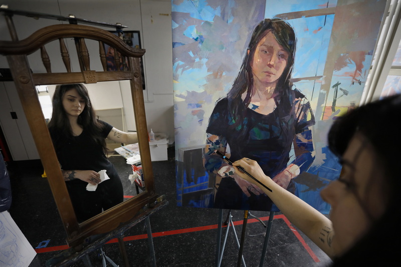 Amanda Arruda works on a self-portrait at her studio on the third floor of the UMass Dartmouth Star Store campus in downtown New Bedford, MA in preparation for her senior painting critique next week. PHOTO PETER PEREIRA