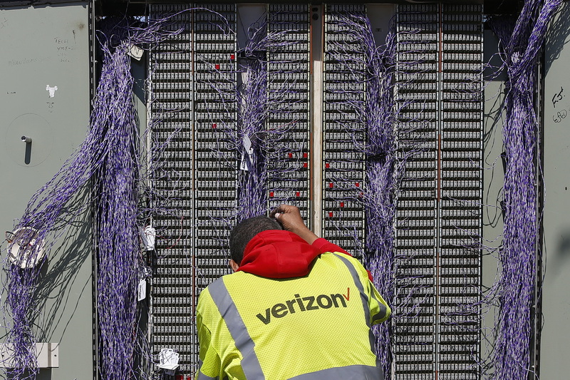 A Verizon technician is faced with a daunting task, as he works on the junction box at the intersection of School Street and Purchase Street in downtown New Bedford, MA.  PHOTO PETER PEREIRA