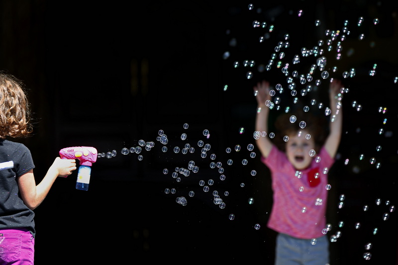 Helen Goss and her brother Von Goss enjoy the weather as they play with bubbles at their grandmothers house in New Bedford, MA. PHOTO PETER PEREIRA