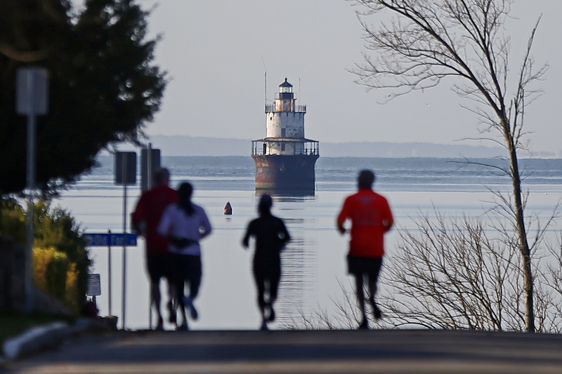 Runners make their way up Green Street in Fairhaven, MA, toward the iconic Butler Flats lighthouse seen in the distance.  PHOTO PETER PEREIRA