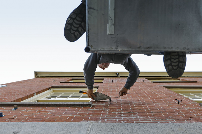 Richard Langlois makes repairs to the brickwork of the sundial building, now part of the Whaling Museum, in downtown New Bedford, MA. PHOTO PETER PEREIRA