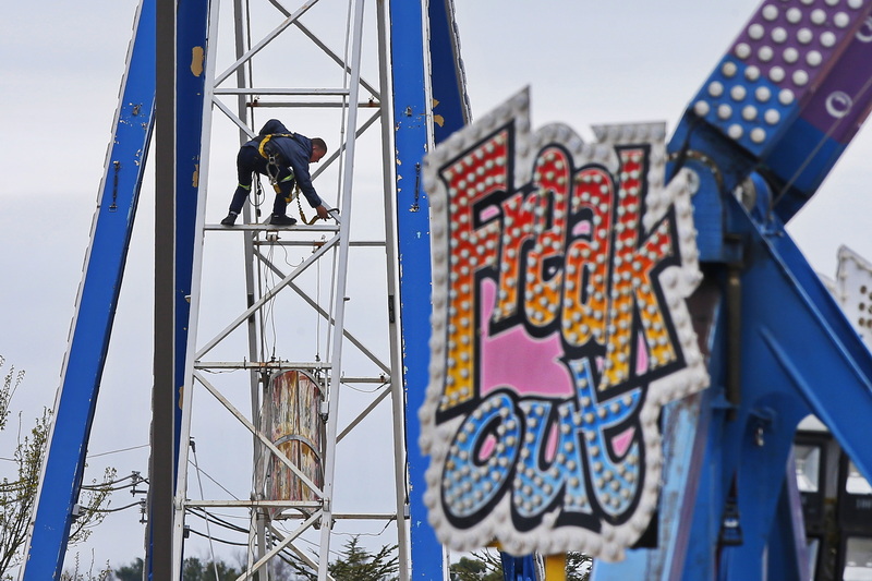 A worker finds himself high above the Dartmouth Mall parking lot installing the Pharaohs Fury ride in preparation for the opening of the carnival this weekend, in the foreground the aptly titled Freak Out ride waits to be ridden. PHOTO PETER PEREIRA