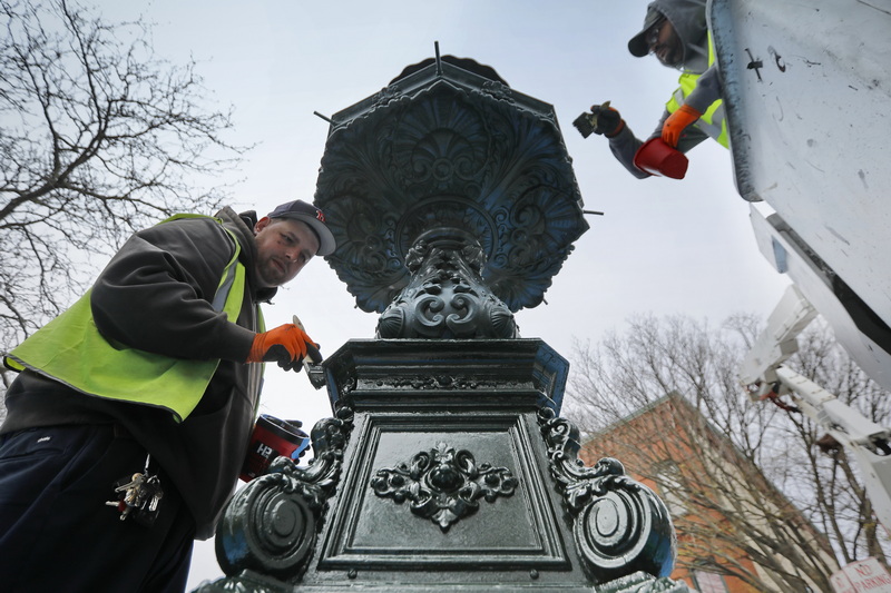 Shawn Cardoso and Carlos Medina put a fresh coat of paint on the fountain at Custom House Square in downtown New Bedford, MA. PHOTO PETER PEREIRA