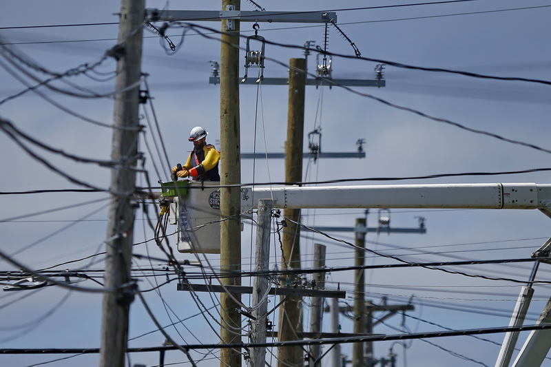 An Eversource worker is surrounded by wires as he makes repairs to utility poles lining Hawthorn Street in New Bedford, MA. PHOTO PETER PEREIRA