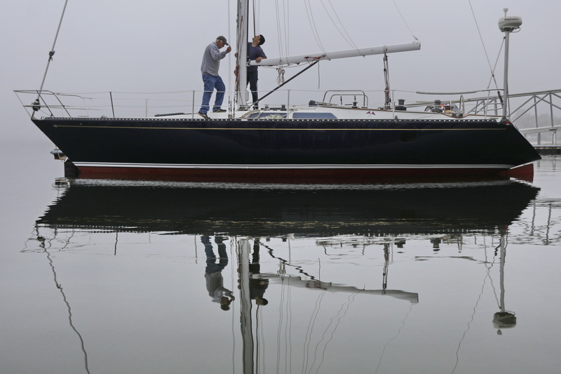 Peter Costa and his son Silas Costa of Triad Boatworks, rig a boat they have just placed in the water in Mattapoisett, MAon a foggy morning, as boaters rush to put their boats in the water for the season. PHOTO PETER PEREIRA