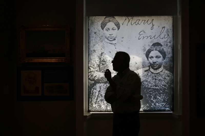 Michael Dyer, co-curator of the Sailing to Freedom: Maritime Dimensions of the Underground Railroad, walks past a backlit daguerreotype showing two teenage sisters, Mary, and Emily Edmonson, who were two of the seventy-seven people captured while seeking freedom aboard the schooner Pearl in 1848 bound for the Delaware Canal.  After traumatic moves between the slave markets of Maryland and New Orleans, the sisters were emancipated through the efforts of Northern abolitionists.  The show will open on Thursday at the Whaling Museum in New Bedford, MA. PHOTO PETER PEREIRA