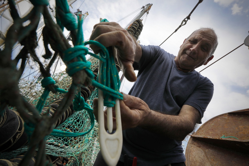 Alvaro Reboca makes repairs to the groundfish netting aboard the Luzo American I fisihing boat docked in New Bedford, MA before heading back out to sea. PHOTO PETER PEREIRA