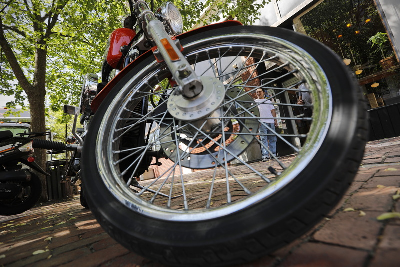 Patrick Nunes takes another look at the Harley Davidson motorcycle he just bought, before going into work at No Problemo in downtown New Bedford, MA.  PHOTO PETER PEREIRA