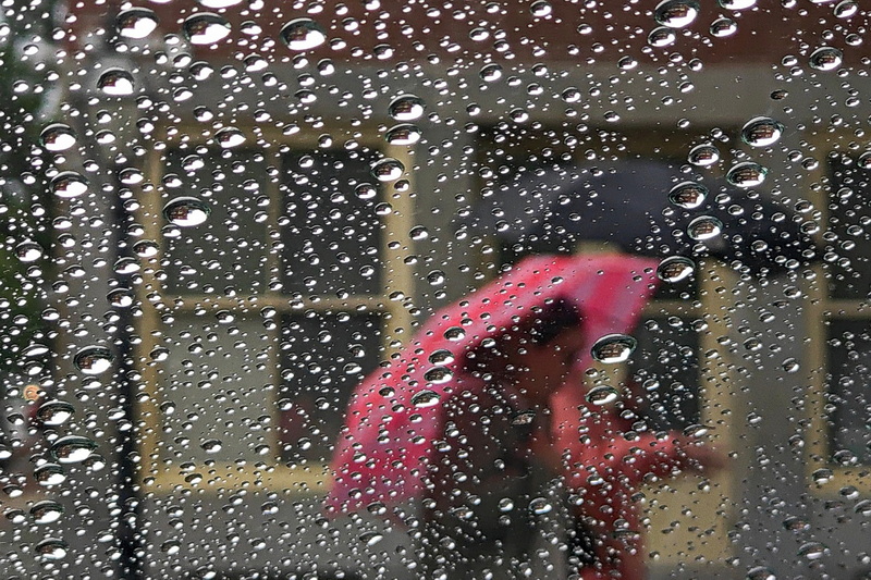 Light rain falls as two women walk up N Water Street in New Bedford, MA past rain drops on a car windshield..  PHOTO PETER PEREIRA