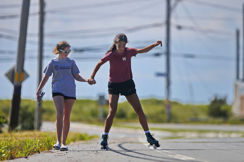 Meagan Kiely gives her friend Angelina Elkhoury a hand as she tries to rollerskate for the first time near Horseneck Beach in Westport, MA.  PHOTO PETER PEREIRA