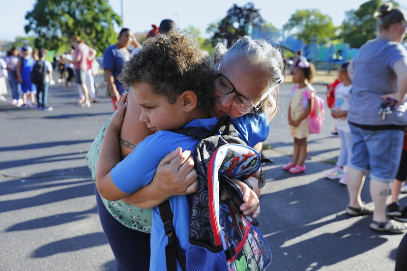 Lisa Lapham hugs her son, Quinton Lapham, 6, as he reluctantly lets go to line up behind the first grade line after arriving for his first day of school at the Alfred Gomes Elementary School in New Bedford, MA. PHOTO PETER PEREIRA