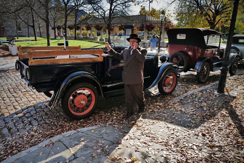 A cast member talks on the phone between filming, next to some vintage cars are parked on the side of Acushnet Avenue as filming continues on a TV show set in the 1930's being filmed in downtown New Bedford.  The show titled Invitation to a Bonfire will air on the AMC network.  PHOTO PETER PEREIRA