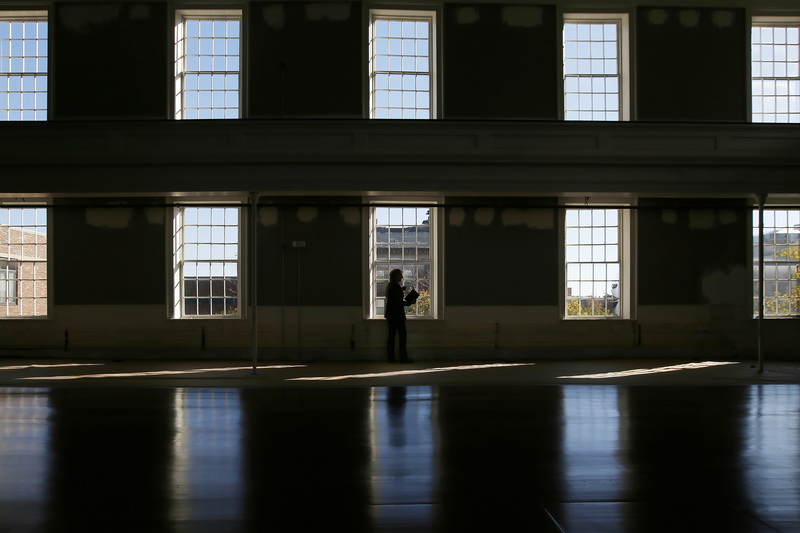 Georgia McDonald, WHALE Development Manager, is framed by the windows of the First Baptist Church in New Bedford, MA as she takes notes in preparation for All Lit Up, where WHALE and Your Theatre invite community members to take a peek inside the almost complete interior of the historic church.  PHOTO PETER PEREIRA