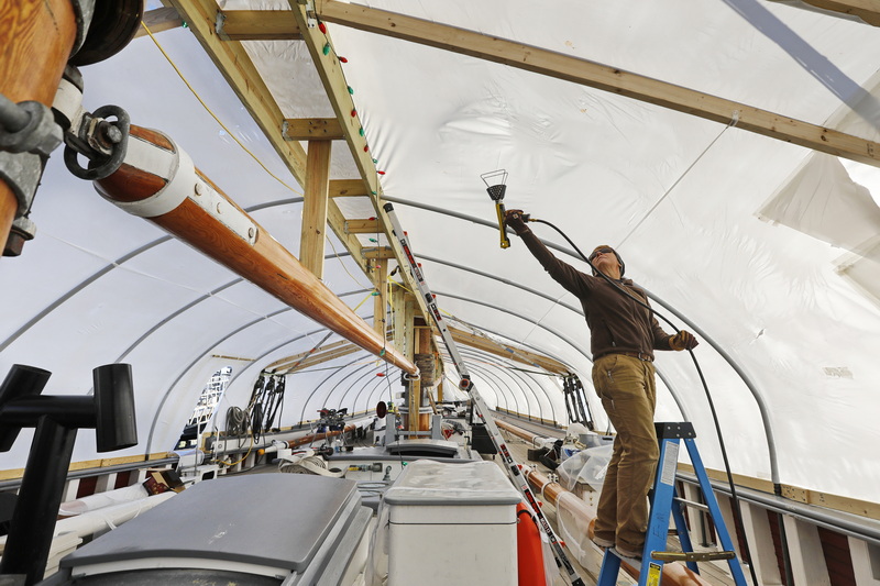 Captain Tiffany Krihwan uses a heat gun to shrink wrap the schooner Ernestina-Morrissey docked at State Pier in New Bedford, MA in preparation for the winter season.  PHOTO PETER PEREIRA