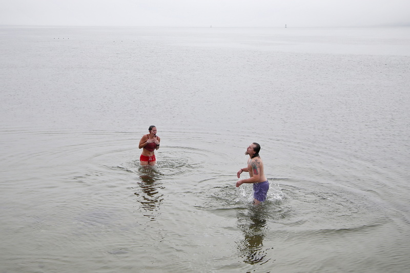 Cori Barboza and Ross Moniz emerge from the cold waters off Fort Phoenix in Fairhaven, MA on a foggy morning.  Ms. Barboza, who was born in the area and currently lives in Las Vegas, wanted to get swim in before flying back to Vegas later in the day after spending the holidays with family. PHOTO PETER PEREIRA