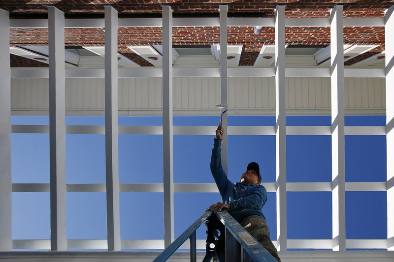 Benjamin Perez paints the trellis work of a residence in Fairhaven, MA. PHOTO PETER PEREIRA