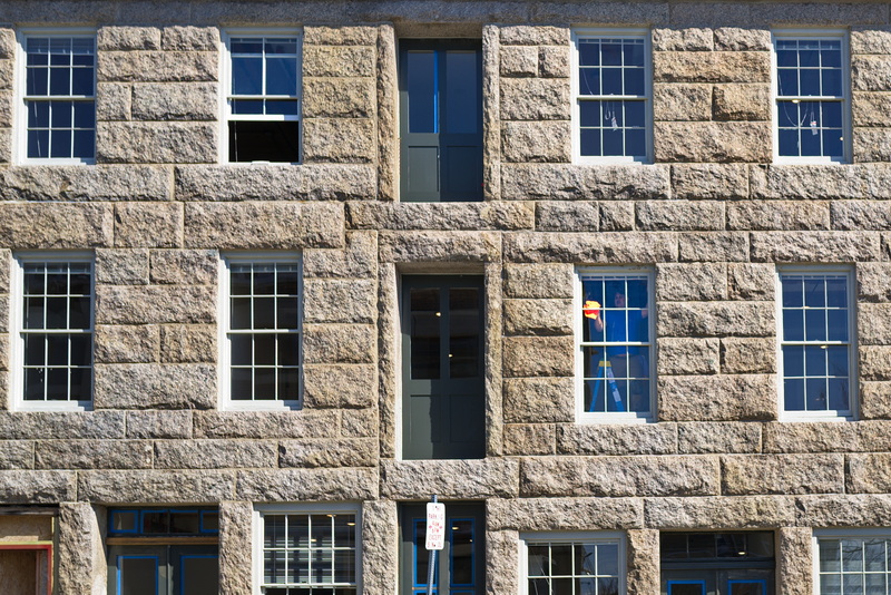 A man is seen cleaning the windows of a historical building being converted into apartment in downtown New Bedford, MA. PHOTO PETER PEREIRA