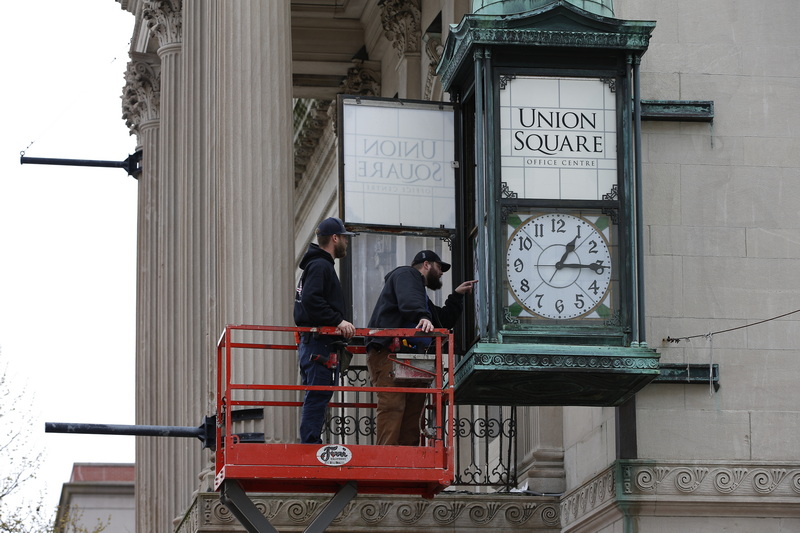 Jay Belanger and Luke Dumas of Dumas Electric open the door to the iconic Union Square clock installed on the side of the former New Bedford Institution for Savings Bank in downtown New Bedford, MA in an effort to make the clock function again. PHOTO PETER PEREIRA