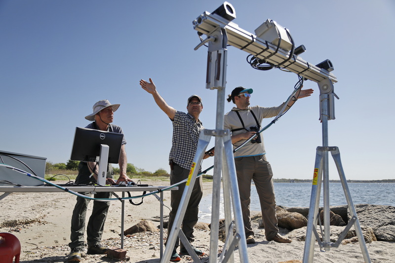 Bio Diversity Institute's biologist Mark DiGirolamo, left monitors the automatic computer results as Andrew Gilbert, center, and quantative ecologist, Evan Adams visually spot birds to confirm results as they test a series of cameras by Pacific Northwest National Laboratories, which are able to spot birds, calculate their position and flight path, at Fort Phoenix in Fairhaven, MA. PHOTO PETER PEREIRA