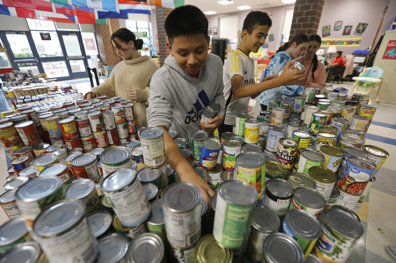 Alex Calel Mateo, 13, and fellow Normandin Middle School eighth graders sort the over three thousand cans they collected throughout the school year to give to the needy for Thanksgiving.  PHOTO PETER PEREIRA