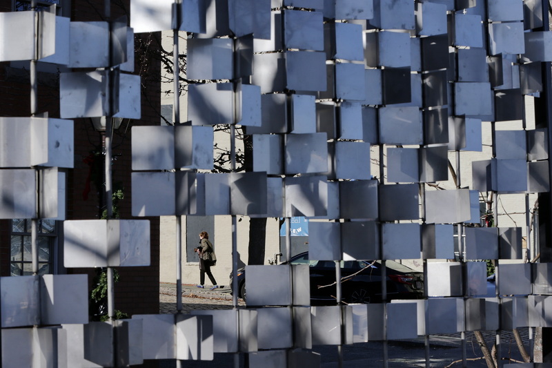 A woman walks up Centre Street in downtown New Bedford, MA. as seen through the gap in an art installation installed on the edge of Route 18. PHOTO PETER PEREIRA