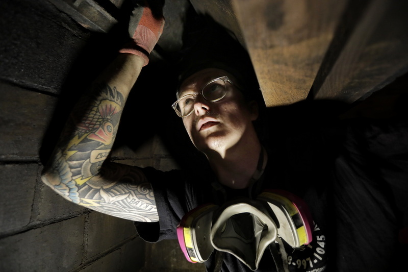 Aidan Parker of Mr. Chimney installs the damper after cleaning the chimney of a fireplace at a home in Mattapoisett, MA.  After cleaning  the chimney Aidan had to tell the homeowner that he should not use the fireplace as their were cracks in the internal brickwork. PHOTO PETER PEREIRA