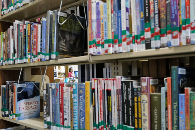 Elizabeth Sherry, director, is seen through a gap in the shelves of the Elizabeth Taylor Library in Marion.  The shelves along with two rooms are going to be renovated thanks to funding by an anonymous donor, with the library expected to be complete April of next year.