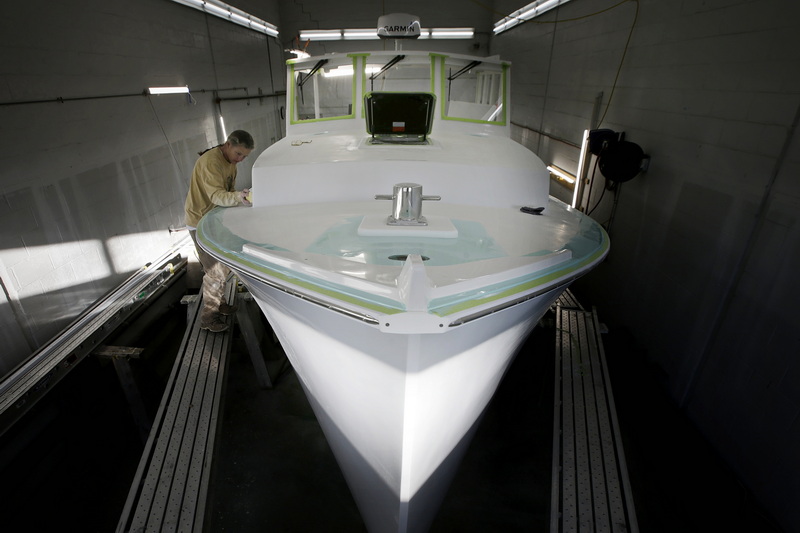 Letitia Costa sands the top section of a new power boat they are making for a client at Triad Boatworks in Mattapoisett, MA. PHOTO PETER PEREIRA