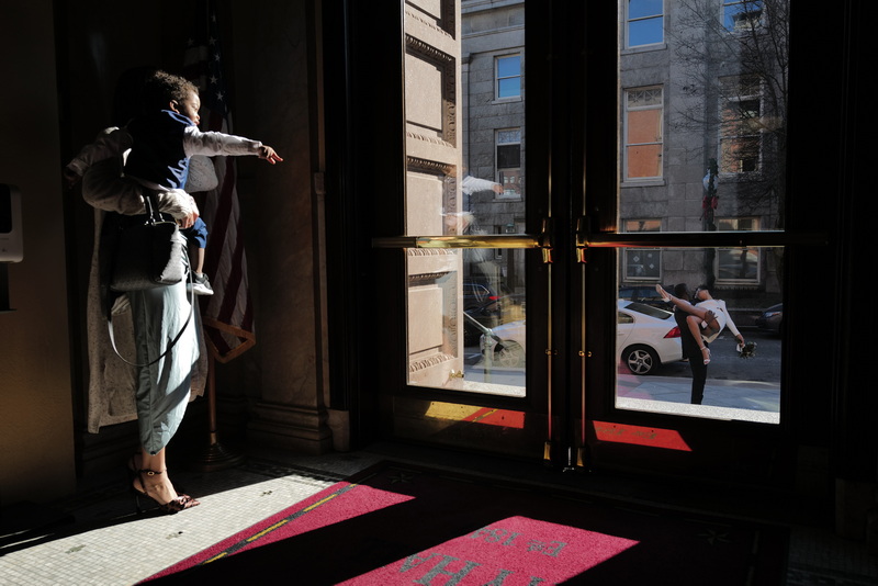 Sarah Houtman holds her nephew Uriah, 2, as he points outside as his parents, Rebekah and Jefferey Romilus, take photos after getting married at New Bedford City Hall. PHOTO PETER PEREIRA