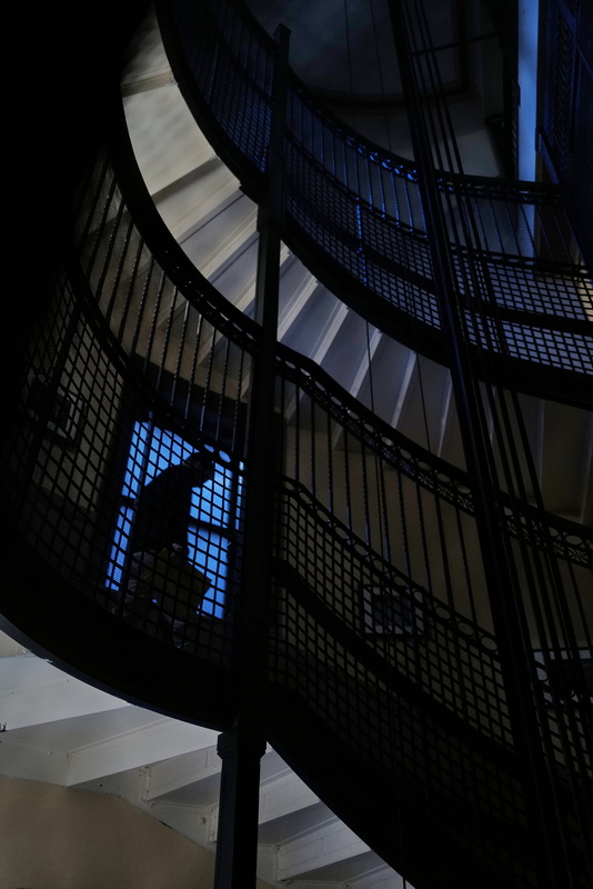 A man walks down the iconic spiral staircase which makes its way around the historic elevator at the center of New Bedford City Hall. PHOTO PETER PEREIRA