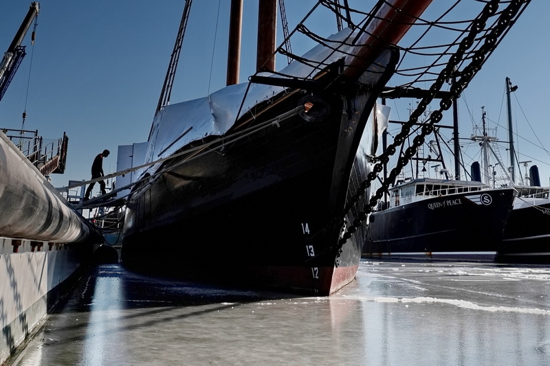 Jackson Horne makes his way aboard the historic schooner Ernestina-Morrissey docked at State Pier in New Bedford, MA surrounded by a frozen section of the harbor. PHOTO PETER PEREIRA