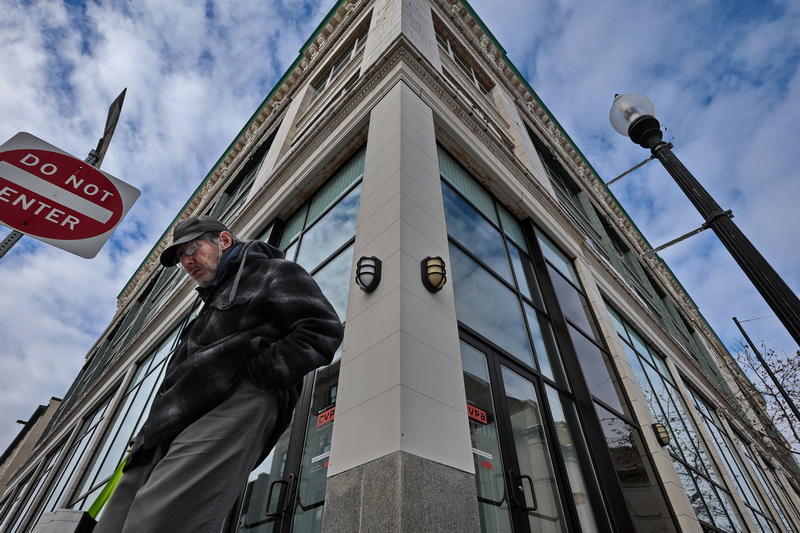 A man makes his up Purchase Street past the former UMass Dartmouth Center for Visual Performing Arts building in downtown New Bedford, MA which still remains unoccupied after the university was made to exit. PHOTO PETER PEREIRA