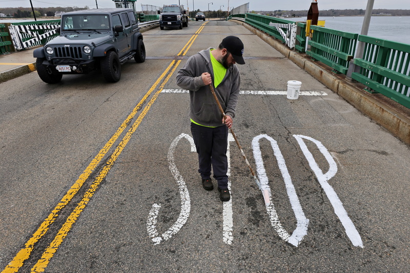 Glenn Chmielorz of the Dartmouth Highway Department, paints the stop sign on the edge of the Padanaram bridge in Dartmouth, MA, which will be closed for repairs. PHOTO PETER PEREIRA