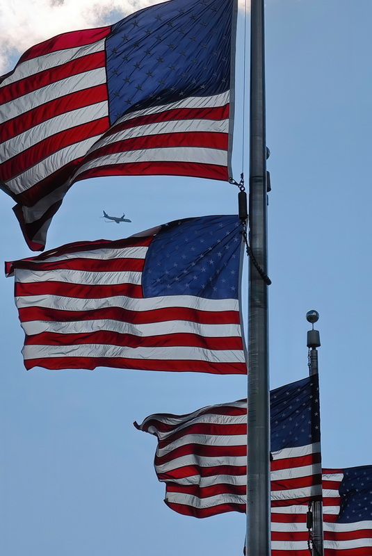 A plane flying out of Ronald Regan International Airport flies across the sky behind the American flags in front of the Washington Monument in Washington D.C. PHOTO PETER PEREIRA